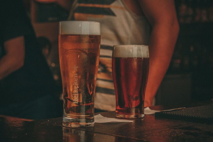 Two glasses of beer on a dark bar counter